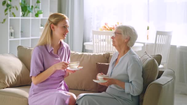 Lachende vrouwen met een kopje thee thuis — Stockvideo