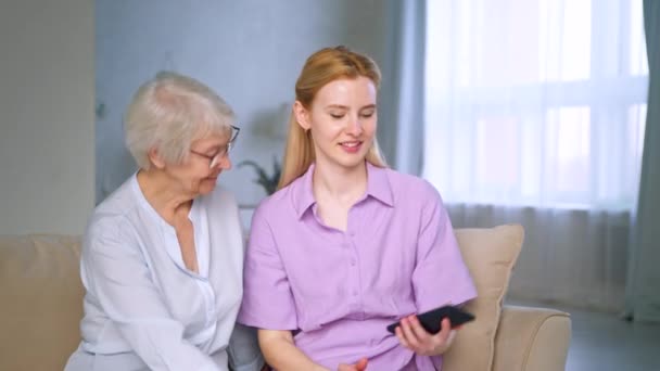 Glimlachende vrouwen met smartphone binnen — Stockvideo