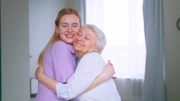 Hugging mom and daughter in the apartment. Elderly mother with daughter hugging — Stock Video