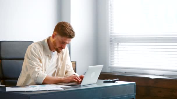 Gerente profesional escribe en el ordenador portátil y examina los informes — Vídeos de Stock