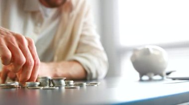 Bulanık şirket yöneticisinin eli masada gümüş para topluyor
