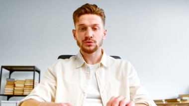 İşçilerle çevrimiçi toplantıda sakallı şirket yöneticisi konuşuyor