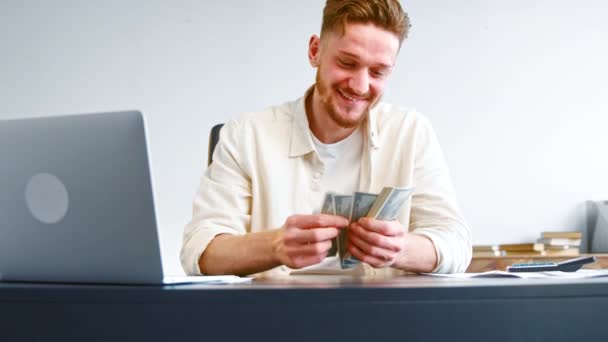 Un hombre de negocios sonriente cuenta los billetes en posesión de ingresos en efectivo — Vídeo de stock