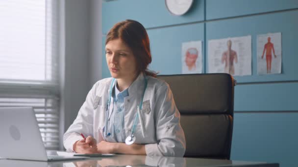 Professional lady doctor conducts online checkup in office — Stockvideo