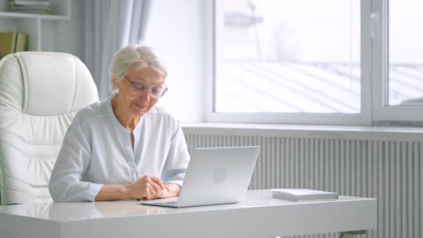 Grey haired mother greets adult children talking via laptop — Stok Video