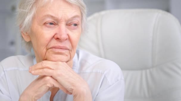 Thoughtful grey haired senior lady looks into window — Stock Video