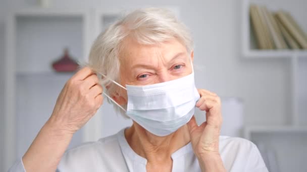 Vieja mujer de negocios con ojos azules se quita la máscara facial — Vídeos de Stock