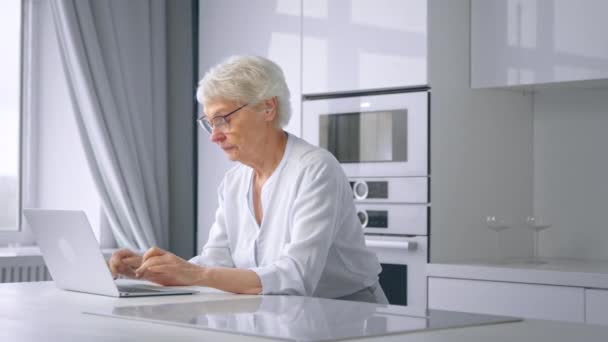 Concentrated aged businesswoman types on laptop at home — Stock Video