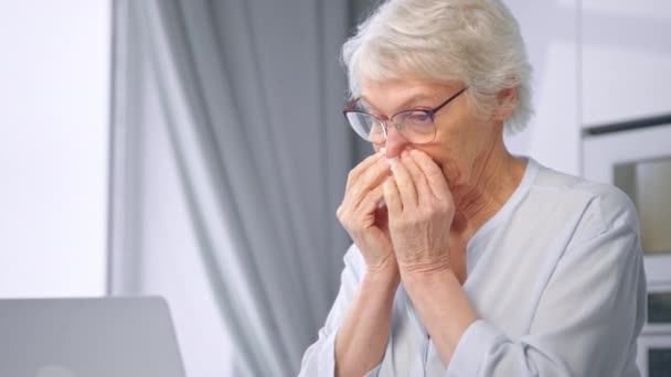 Upset aged businesswoman in glasses wipes nose with napkin — Stockvideo