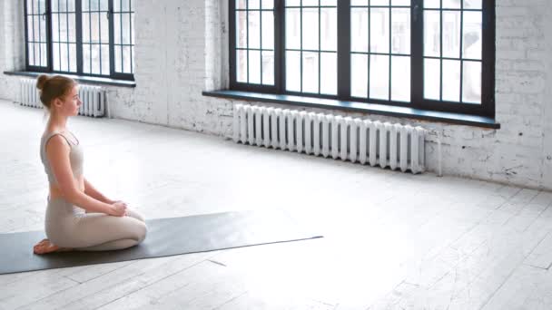 Спортивна жінка в спортивному костюмі стоїть в дощатій позі на килимку — стокове відео