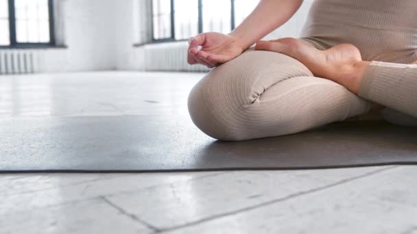 Sportiva signora in leggings si siede in posa loto yoga sul tappeto — Video Stock