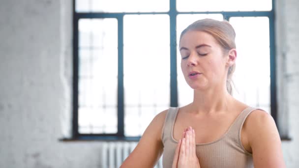 Lady with closed eyes breathes deeply in light yoga studio — Αρχείο Βίντεο