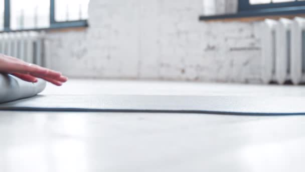 Жіночий тренер катається гумовий килимок після тренування на підлозі — стокове відео