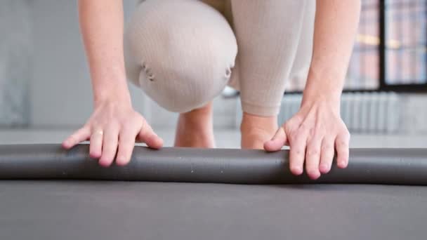 Fitness trainer rola novo tapete de borracha no chão no estúdio de ioga — Vídeo de Stock