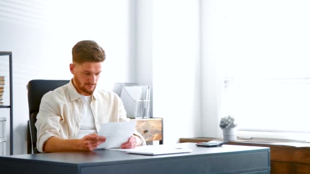 Contable barbudo calificado mira a través de informes de papel — Vídeos de Stock