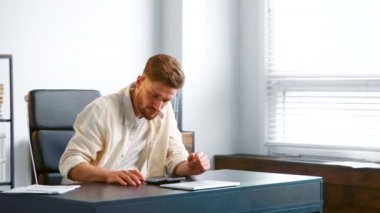 Serious businessman with beard counts expenses on calculator