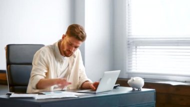 Guy manager assistant with beard looks into sheets of papers