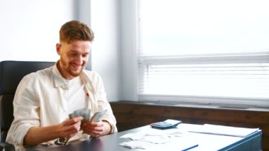 Successful businessman with beard gathers money banknotes