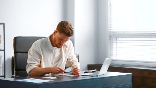 Professional accountant with beard sorts small paper checks — Stok Video