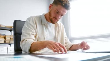 Shocked bank accountant man with beard looks at checks