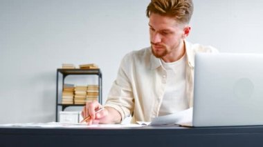Experienced analyst checks sheets of papers with reports
