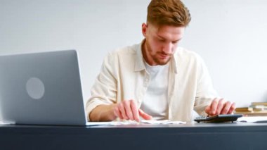 Skilled accountant looks at paper checks and summaries