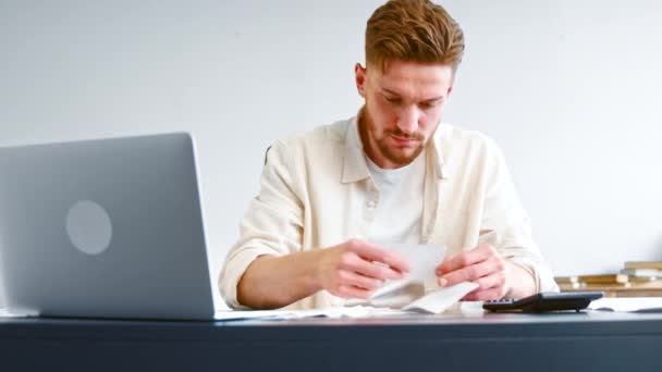 Bearded company analyst in yellow shirt analyzes check sums — Stockvideo