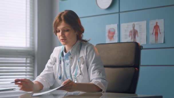 Ung kvinna terapeut talar med patient innehav papper — Stockvideo