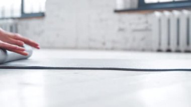 Bayan, hafif yoga stüdyosundaki eğitimden sonra paspas yuvarlıyor.