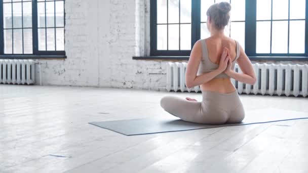 Elegante yoga beoefenaar doet omgekeerde namaste op vloer — Stockvideo