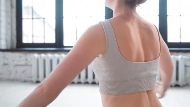 Jonge yoga trainer toont omgekeerde namaste in lichte studio — Stockvideo