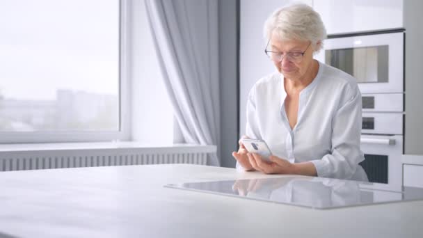 Lady pensionato naviga internet su smartphone con sorriso felice — Video Stock