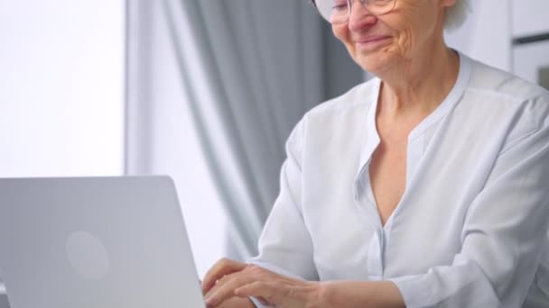 Professional woman secretary types on grey laptop and smiles — Stockvideo