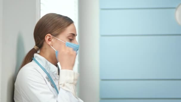 Brunett sjuksköterska tar av blå engångs ansikte mask — Stockvideo
