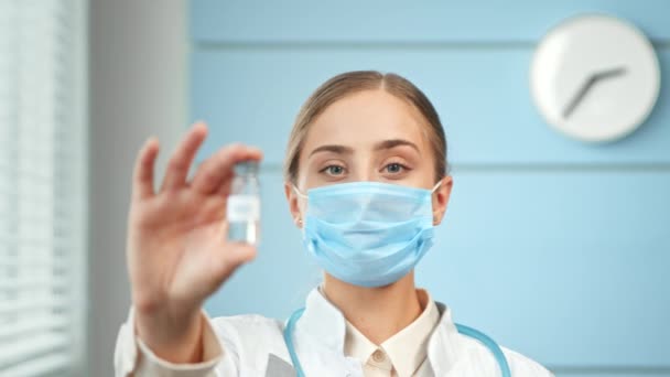 Young woman researcher in white coat and blue face mask — Video