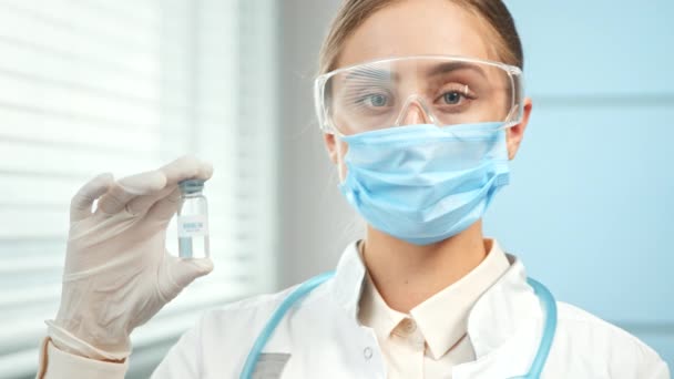 Young woman researcher holds transparent vial with vaccine — Video