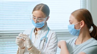 Professional lady general practitioner injects patient