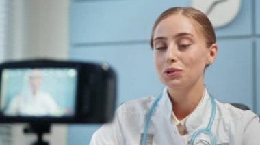 Young woman blogger in medical coat with stethoscope