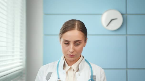 Professionele jonge vrouw arts in jas met stethoscoop — Stockvideo