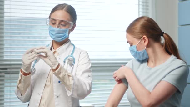 Profesjonalna pielęgniarka wstrzykuje młodej kobiecie — Wideo stockowe