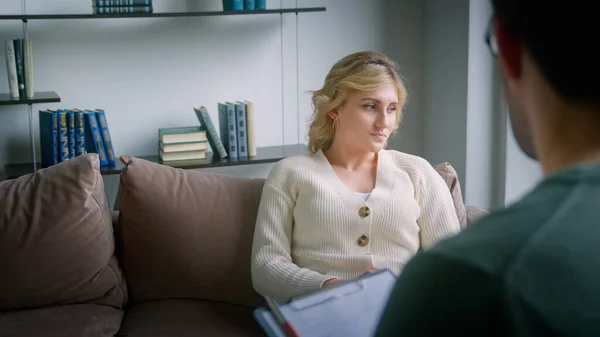 Jonge vrouwelijke patiënt in gesprek met de dokter tijdens de psychologische sessie — Stockfoto