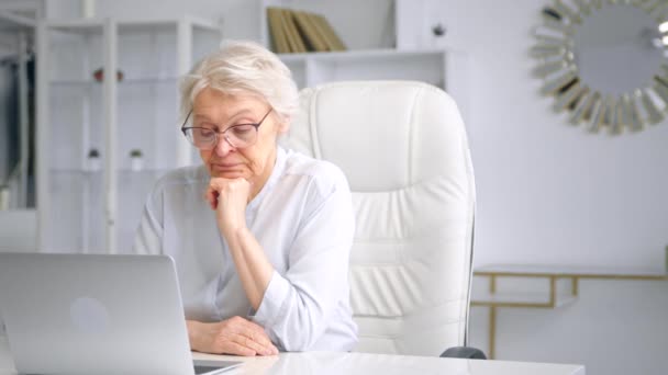 Aburrido anciana con pelo gris mira en pantalla con ira — Vídeos de Stock