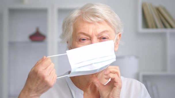 Улыбающаяся пожилая деловая женщина выглядит натуралом и надевает маску — стоковое видео