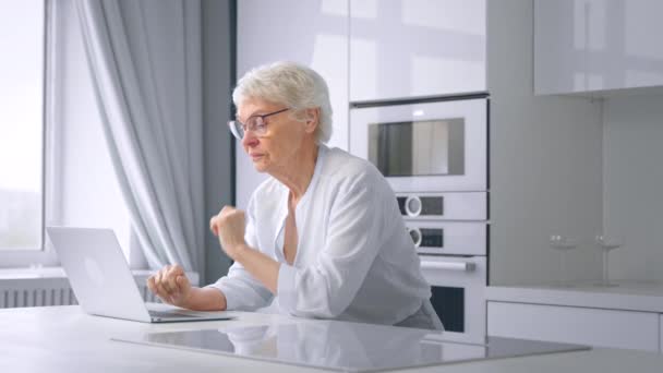 Exhausted old businesswoman takes glasses off in kitchen — Stock Video