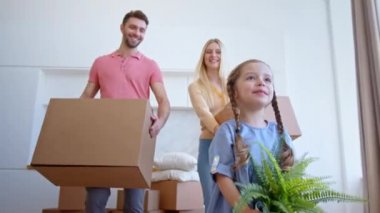 Gülümseyen aile babası kadın ve çocuk yeni daire boyunca yürür.