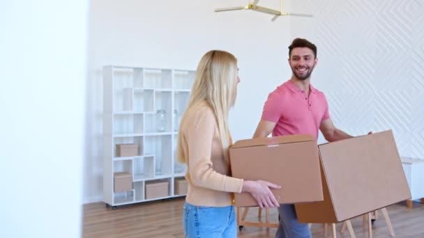 Casal apaixonado olha nos olhos andando ao longo de nova sala plana — Vídeo de Stock