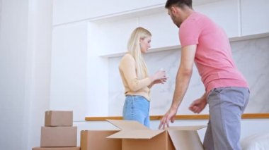 Tişörtlü sakallı koca paketten gözlük alıyor.