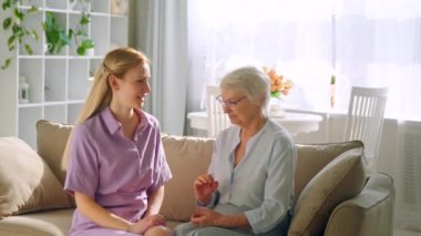 Gülümseyen kız ve yaşlı anne konuşuyor.