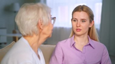 Farklı yaşlardaki kadınlar kanepede konuşuyor.