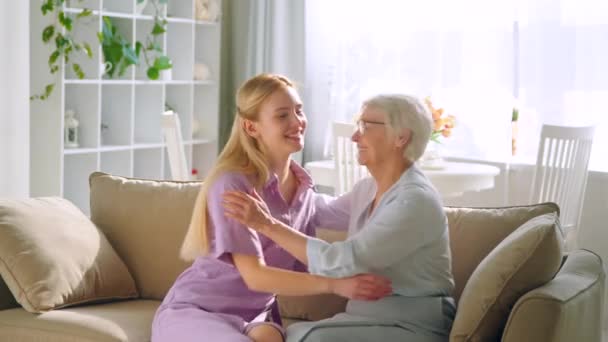 Jong meisje en bejaarde vrouw omarmen — Stockvideo